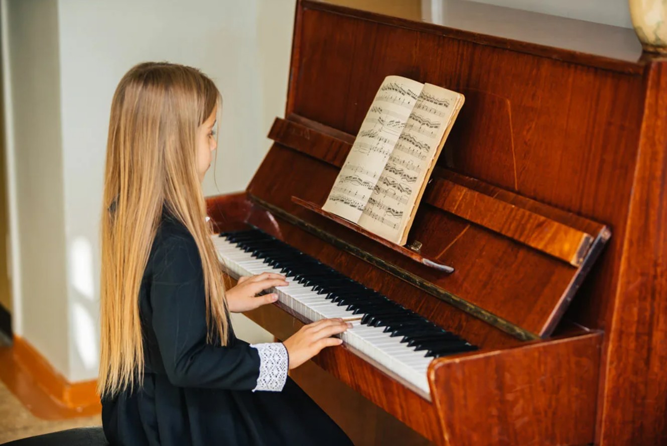 Listen she is playing the piano. Фортепиано. Ребенок за фортепиано. Девочка за пианино. Ребенок за роялем.